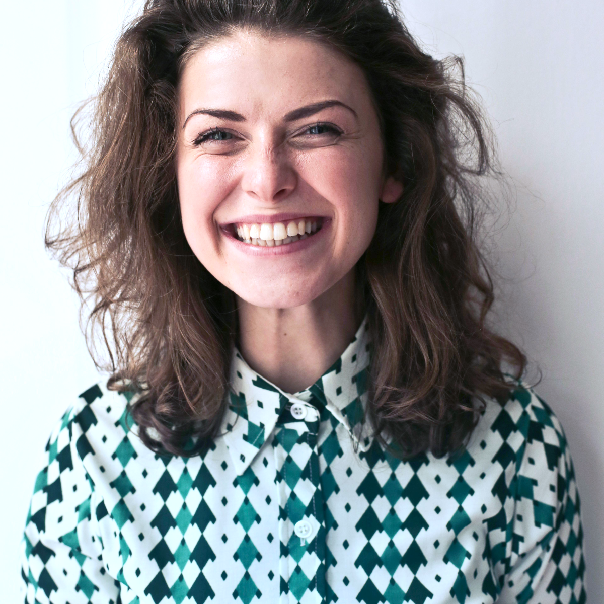 Woman with natural smile standing in soft window light